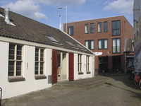 907748 Gezicht op het nieuwe hoekpand met appartementen en de fietsenwinkel van Huijsen Tweewielers (Draaiweg 5 en ...